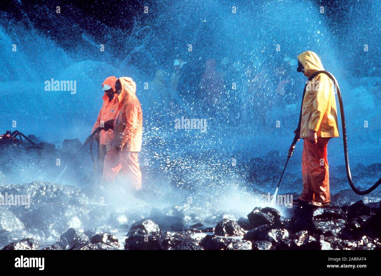 Prince William Sound, AK (Mar. 28)--lavoratori sbuffo di vapore rocce imbevuto di petrolio greggio dal perde petroliera Exxon Valdez. La Exxon Valdez si è arenata sulla Bligh Reef in Prince William Sound, Alaska, 23 marzo 1989 la fuoriuscita di 11 milioni di galloni di petrolio greggio che ha provocato la più grande marea nera nella storia degli Stati Uniti. Foto Stock