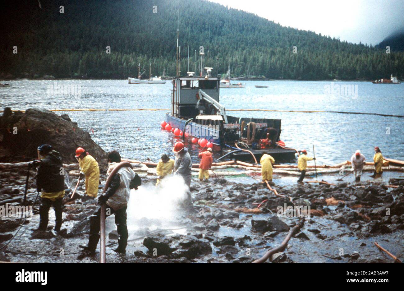 Prince William Sound, AK (Mar. 28)--Cleanup continua come lavoratori sbuffo di vapore rocce e le coste di lavaggio imbevuto di petrolio greggio dal perde petroliera Exxon Valdez. La Exxon Valdez si è arenata sulla Bligh Reef in Prince William Sound, Alaska, 23 marzo 1989 la fuoriuscita di 11 milioni di galloni di petrolio greggio che ha provocato la più grande marea nera nella storia degli Stati Uniti. Foto Stock