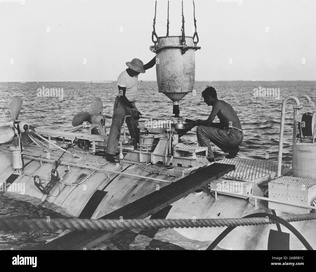 Jacques Piccard (a destra), co-designer di Trieste e Ernest Virgilio ferro carico zavorra shot nel sotto prima di una prova di discesa nella trincea di Marianne, nov. 15, 1959. Foto Stock