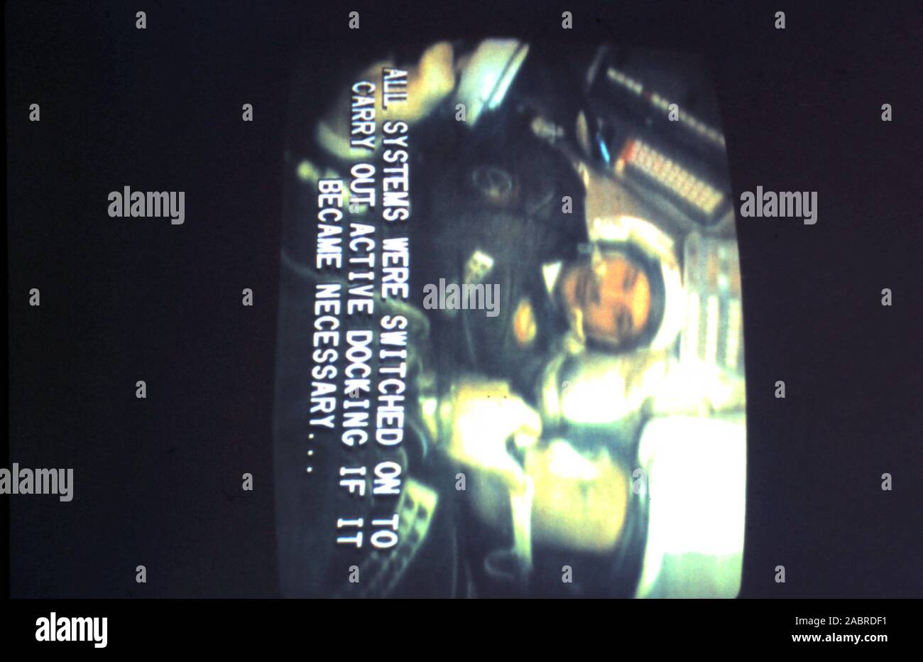 Teleclip - Apollo-Soyuz Test del progetto - "Tutti i sistemi sono stati accesi per effettuare docking attivo se è diventato necessario...' subtitle; - Alexei Leonov - Valeri Kubasov all'interno di Soyuz 19 capsule momenti prima di docking con Apollo CSM-111 - foto scattata direttamente da TV a colori schermo nel Regno Unito - da "Harry' (il fotografo sconosciuto) durante le trasmissioni dal vivo nel luglio 1975. L' Apollo-Soyuz Test Project (ASTP) (Russo: Экспериментальный полёт "Аполлон" - "Союз" (ЭПАС), Eksperimentalniy polyot Apollon-Soyuz. 'Volo sperimentale Apollo-Soyuz', comunemente indicati dai sovietici come Soyuz-Apollo), Foto Stock