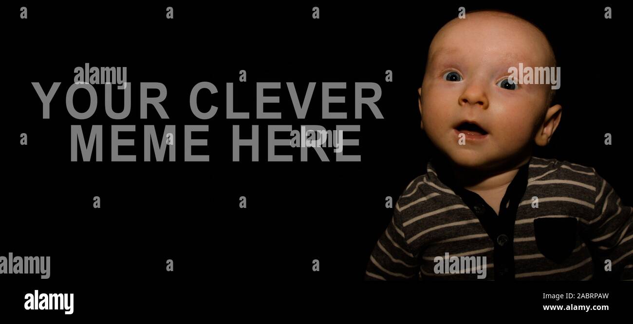 Un bambino di 4 mesi pone su uno sfondo nero. Perfetto per i memi con copia spazio. Foto Stock