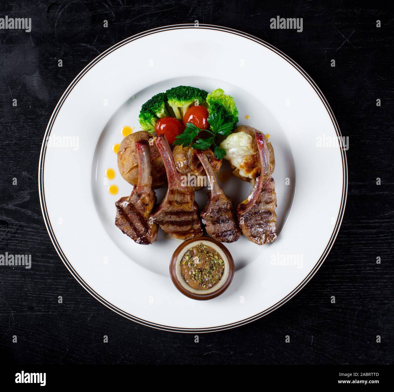 Costolette di carne in salsa con patate al forno e broccoli Foto Stock