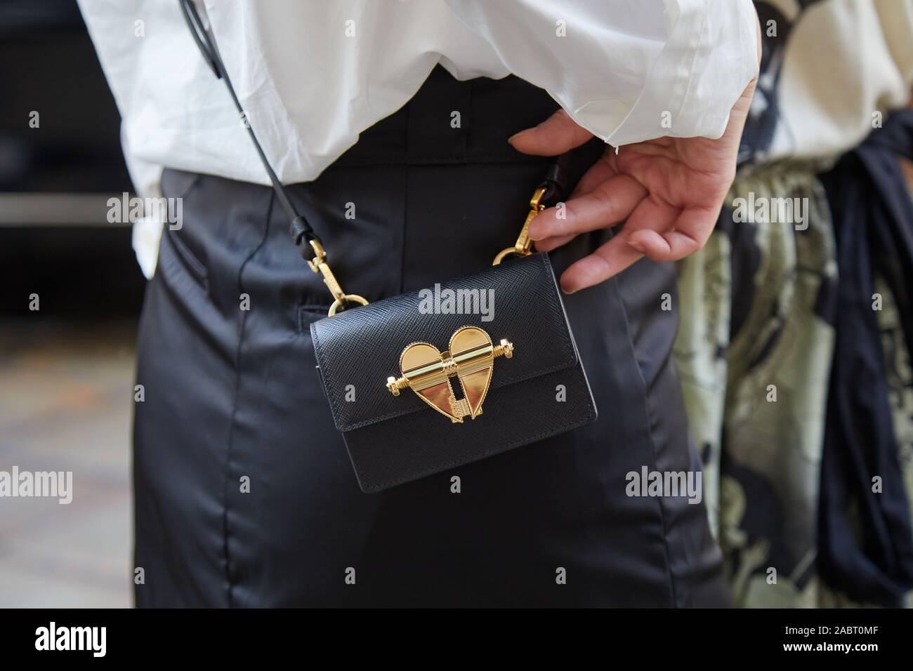 Milano, Italia - 18 settembre 2019: donna in pelle nera borsa di Prada con cuore d'oro prima di Peter Pilotto fashion show, la Settimana della Moda Milanese street s Foto Stock