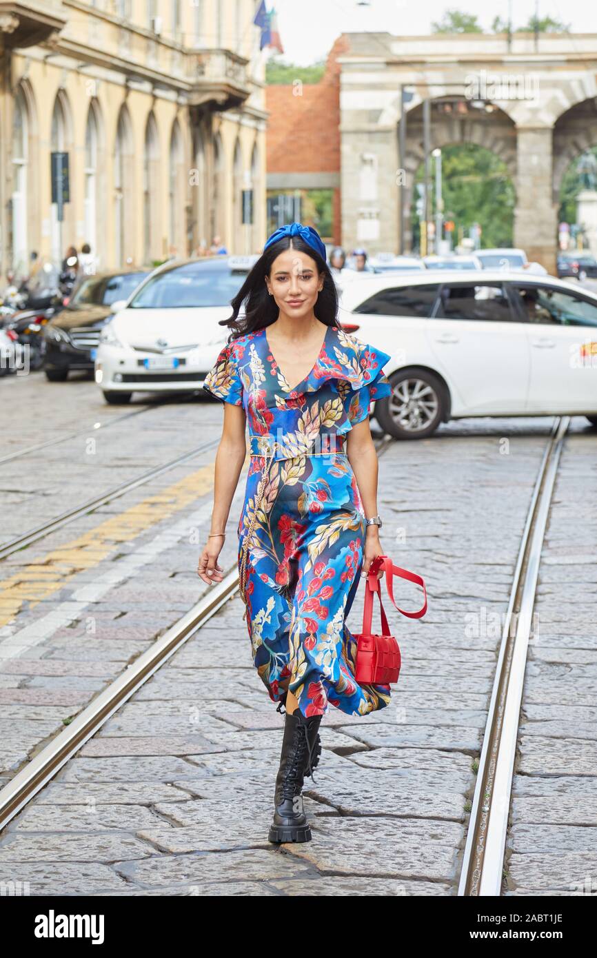 Milano, Italia - 18 settembre 2019: Donna con motivi floreali blu e vestito  rosso borsa in pelle a piedi prima di Peter Pilotto fashion show, la  Settimana della Moda Milanese stre Foto stock - Alamy