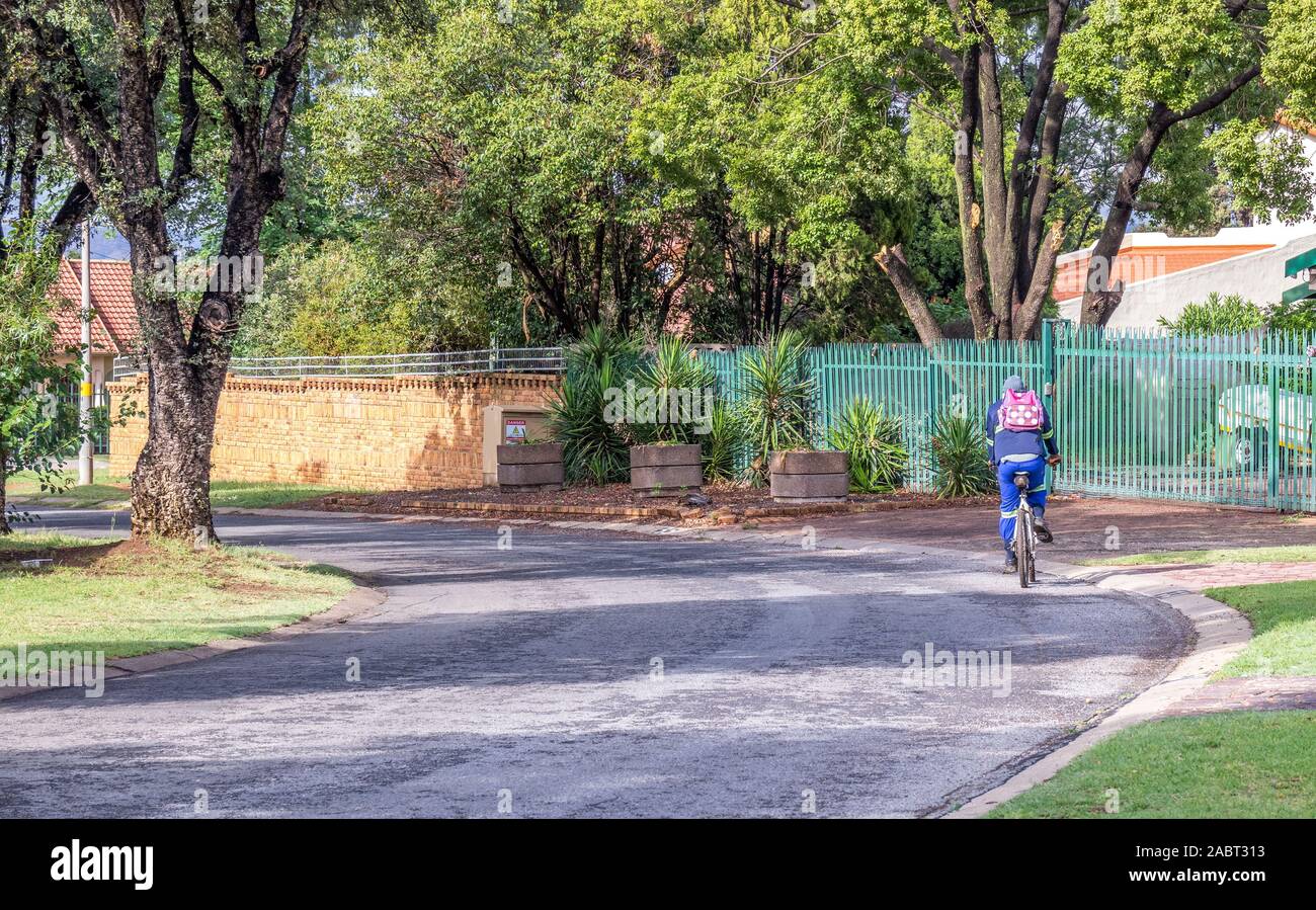 Alberton, Sud Africa - unidentified ciclista cavalca una bicicletta su una strada attraverso il sobborgo di Brackendowns immagine in formato orizzontale Foto Stock