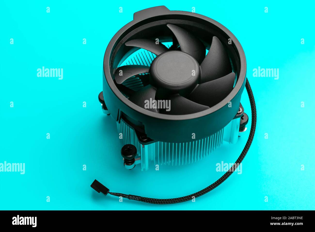 Ventola di raffreddamento su un sfondo turchese. Un singolo oggetto. Nero ventilatore del computer. Raffreddatore del pc. Foto Stock