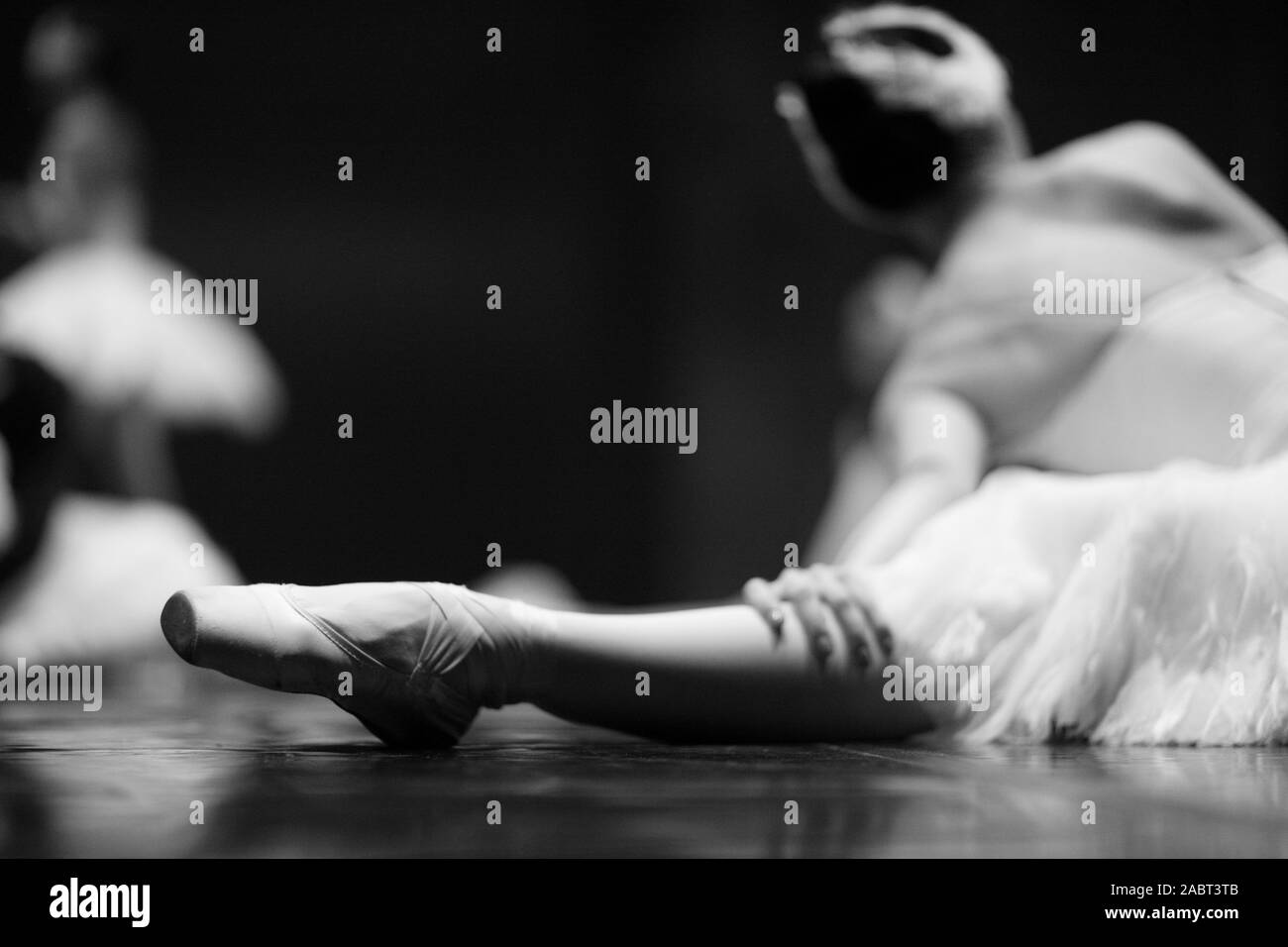 Silhouette di una ballerina seduta sul palco al momento di una pausa durante le prove Foto Stock