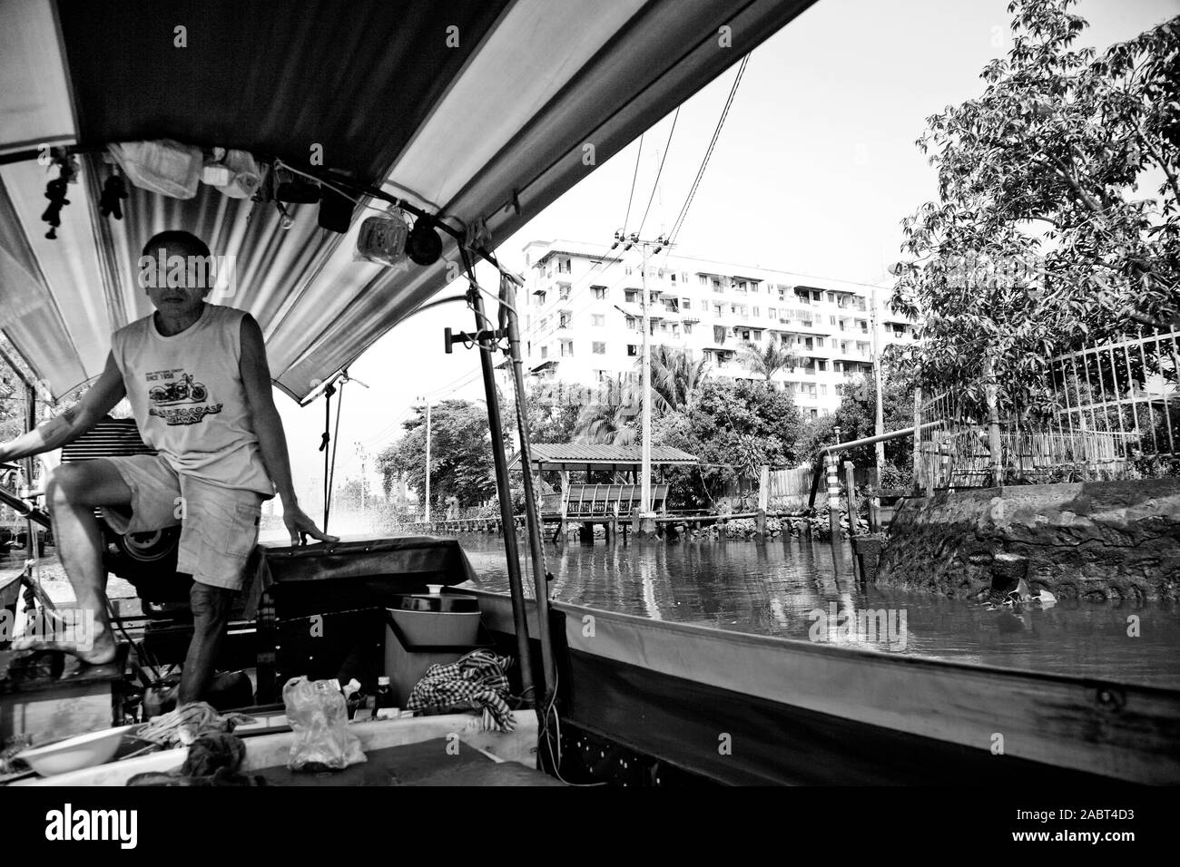 L'uomo il pilotaggio di una barca dalla coda lunga a Bangkok, in Thailandia Foto Stock