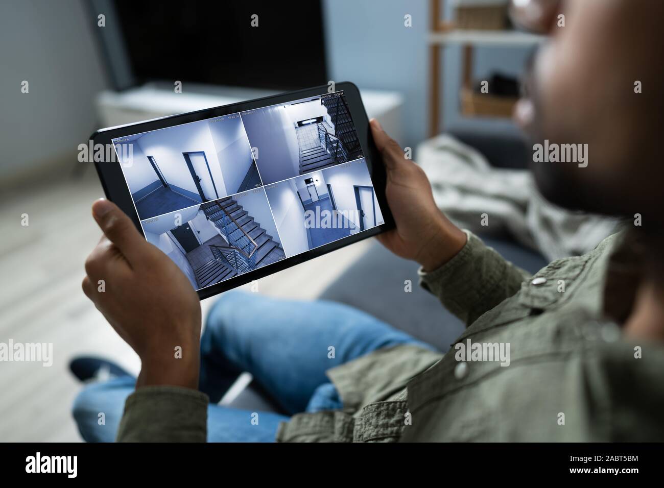 Persona le telecamere di monitoraggio Live View di casa sulla tavoletta digitale Foto Stock