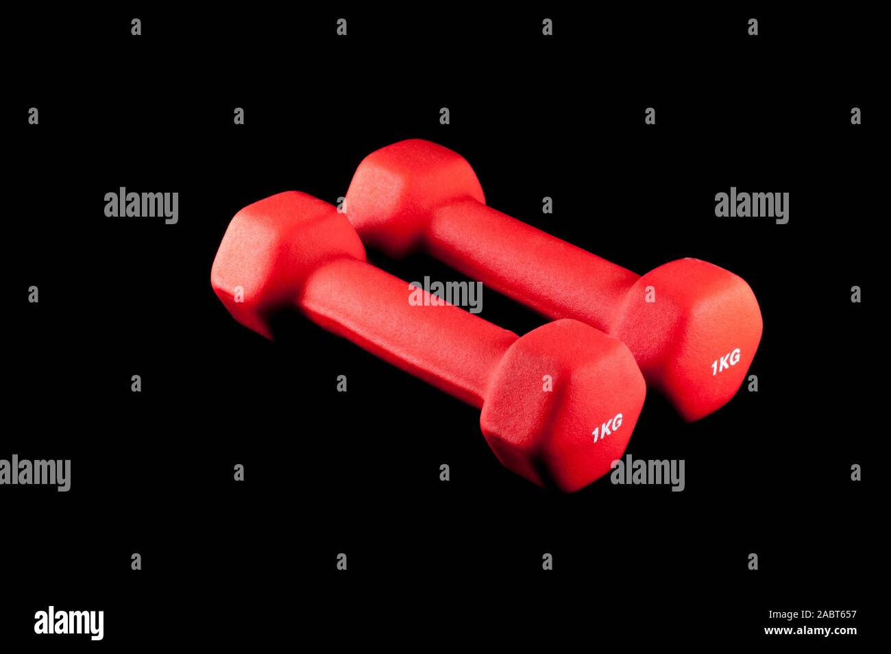 Coppia di due rosso 1 kg manubri su sfondo nero Foto Stock