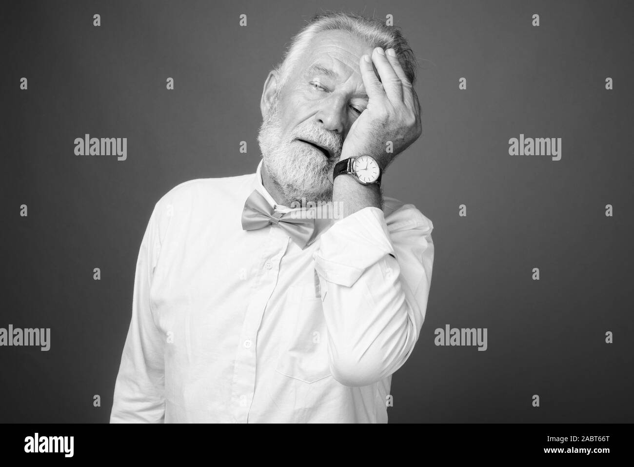 Bello barbuto uomo senior indossando abiti eleganti in bianco e nero Foto Stock