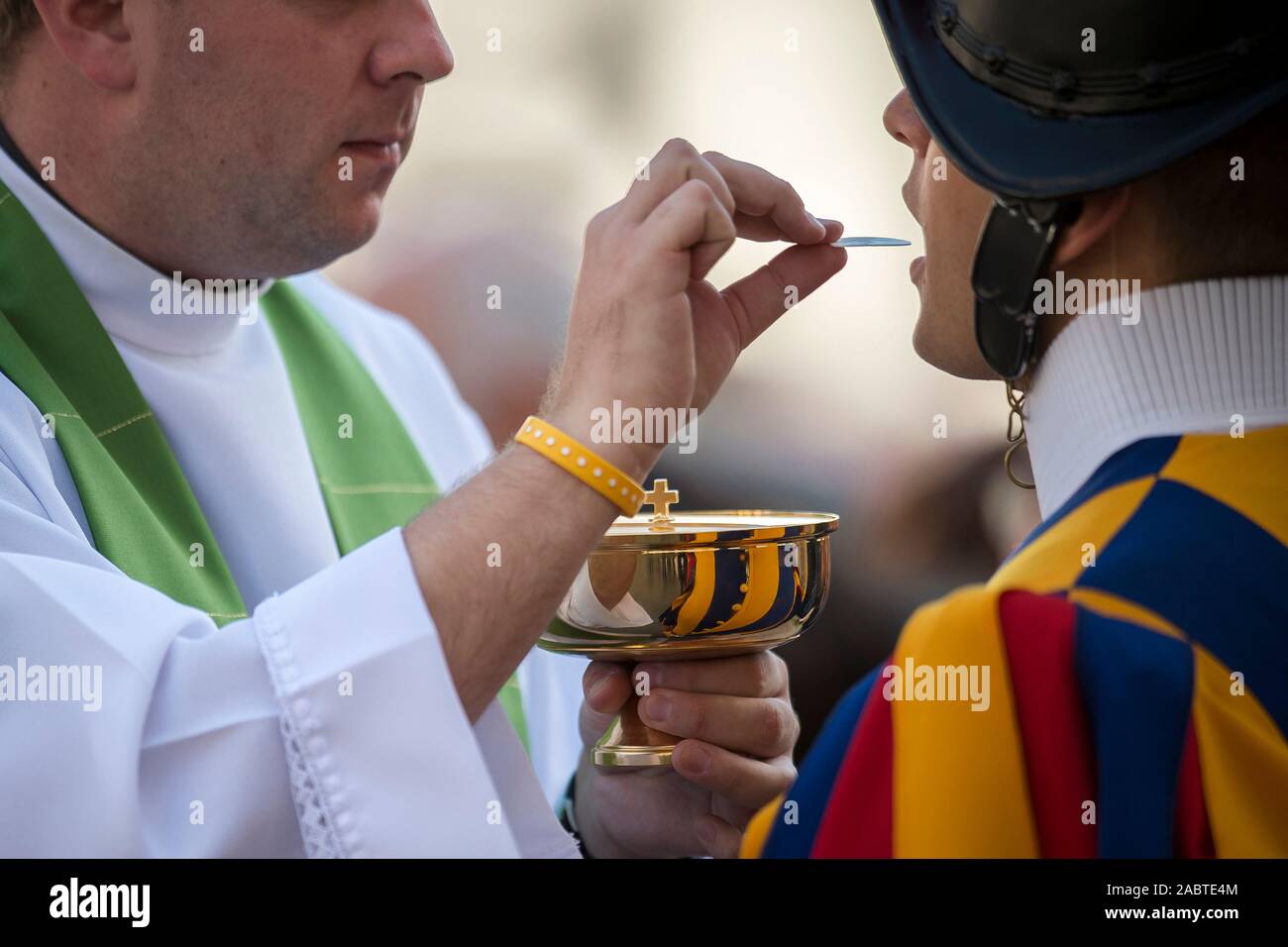 Sacerdote cattolico di dare la santa comunione per una Guardia Svizzera, Città del Vaticano. Foto Stock