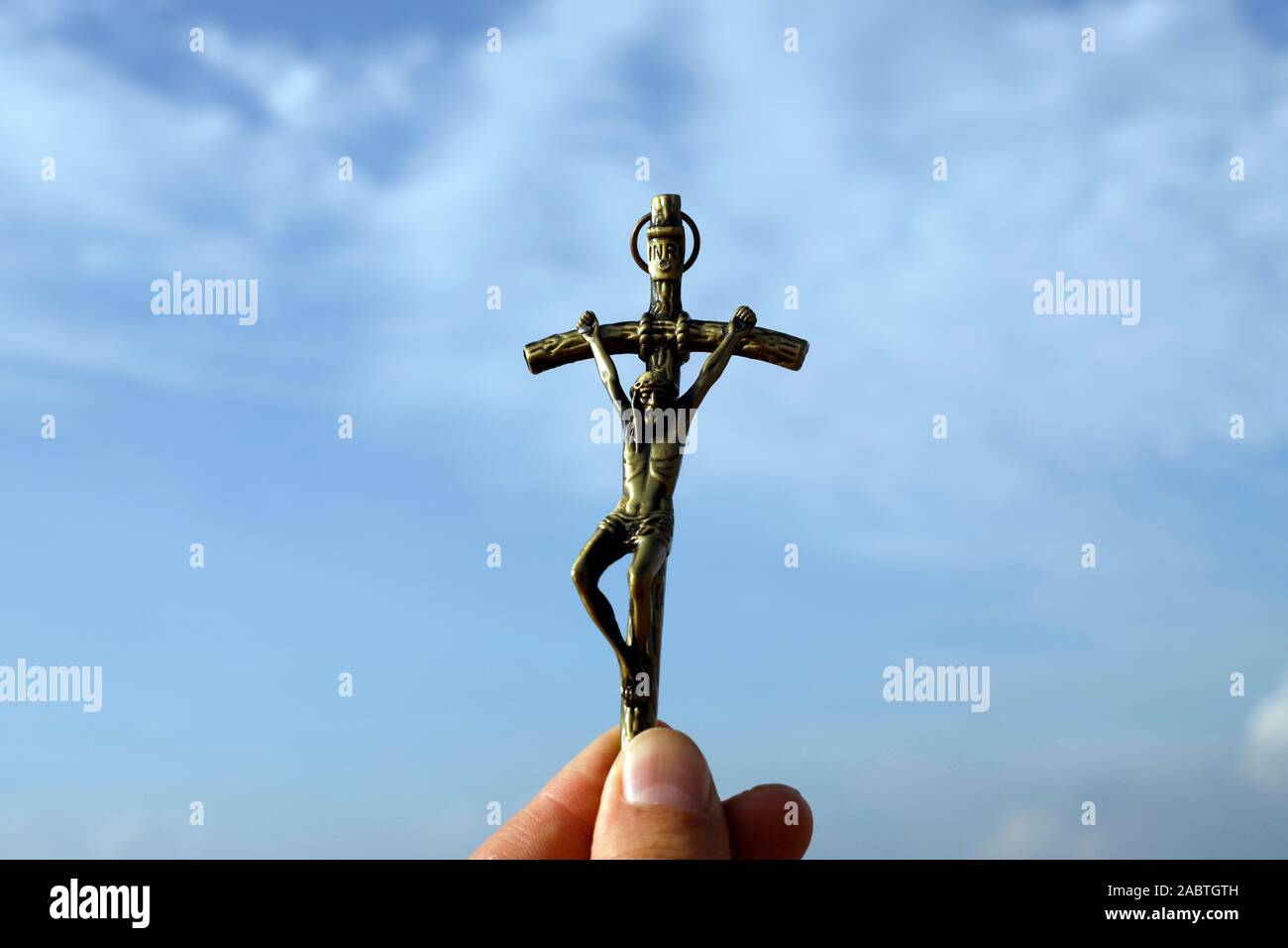 L'uomo crocifisso di contenimento contro il cielo blu. Close-up. Foto Stock