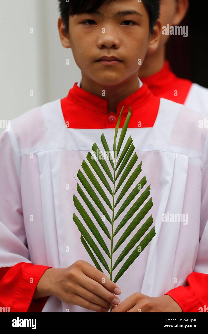 Domenica delle Palme. Altare ragazzo con un ramo di palma. Hoi An Cattedrale. Il Vietnam. Foto Stock