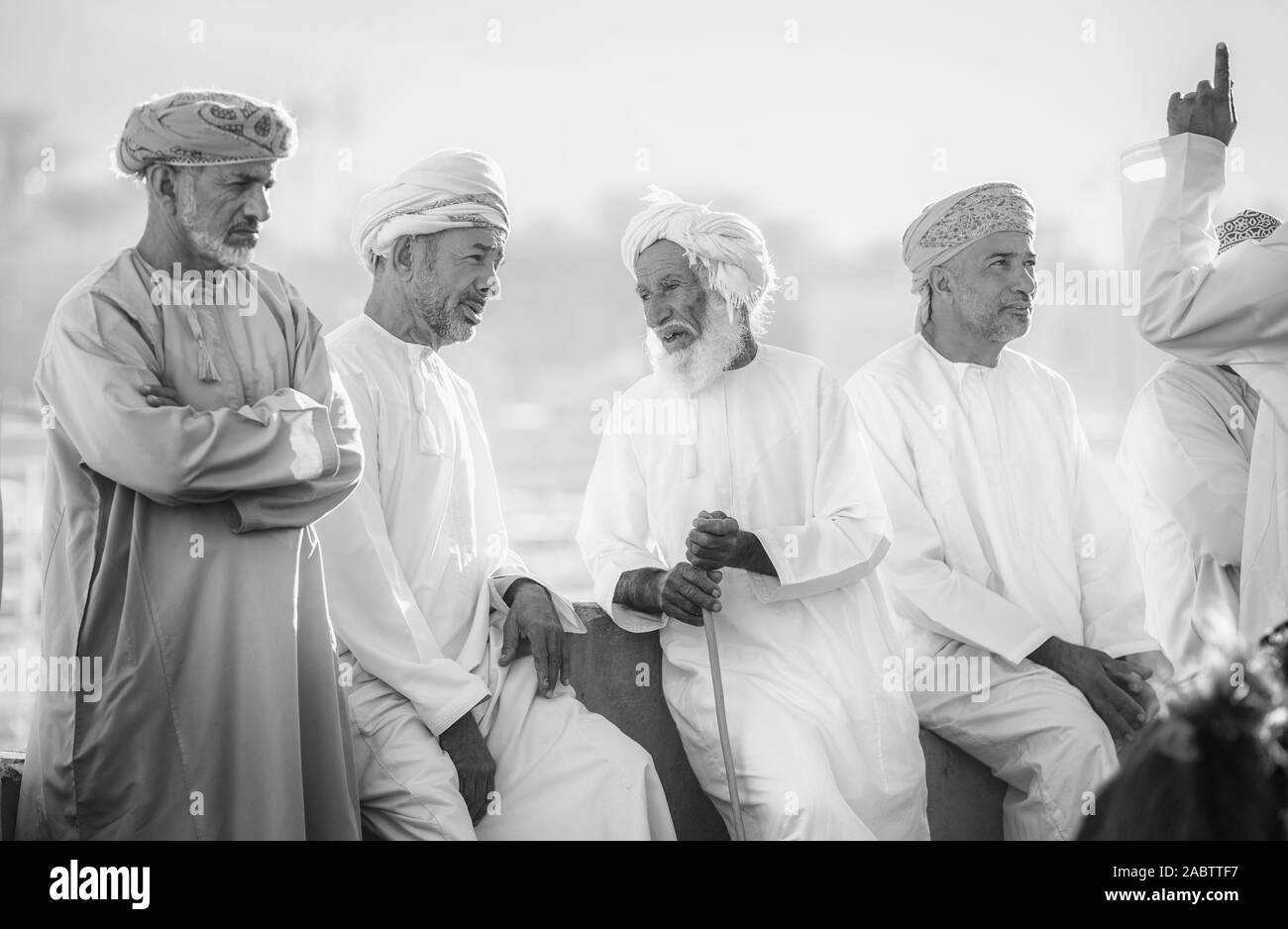 Nizwa, Oman, Dicembre 2015: omani uomini socializzare presso il vecchio Nizwa mercato di capra Foto Stock