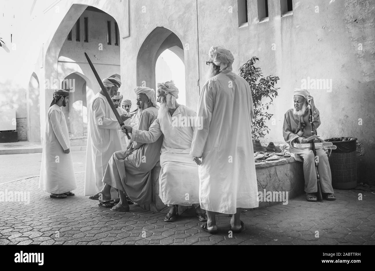 Nizwa, Oman, Dicembre 2015: omani uomini socializzare presso il vecchio Nizwa mercato di capra Foto Stock