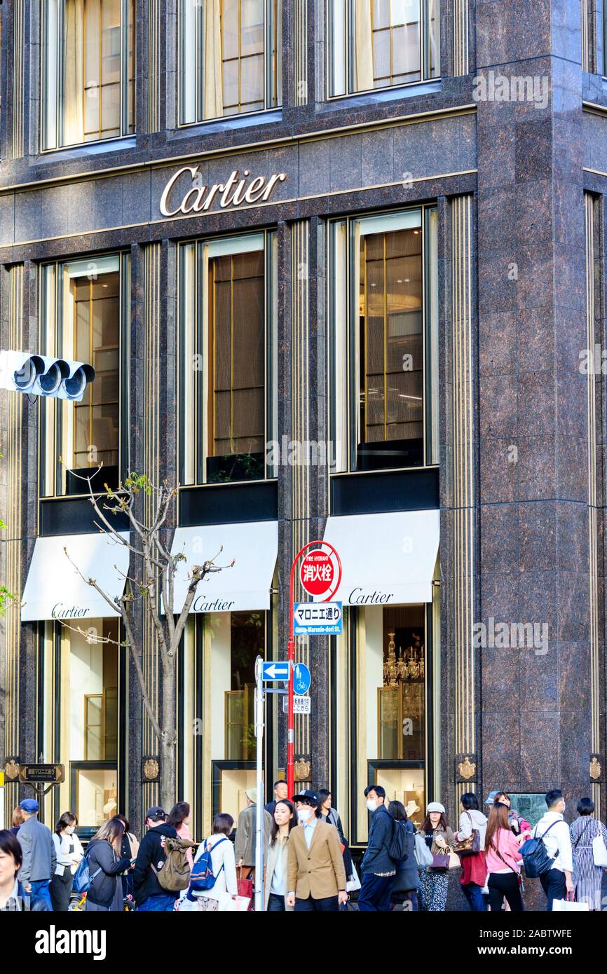 La boutique Cartier Tokyo Ginza la costruzione di fronte con la visualizzazione di finestre e marciapiede esterno occupato e affollate di persone. Il giorno, la primavera. Foto Stock