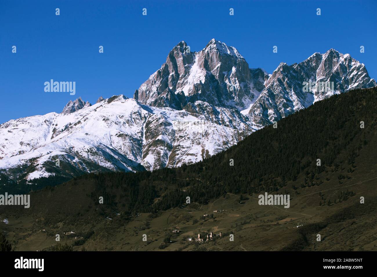 Antiche Torri di avvistamento e di un villaggio in Svaneti Georgia sullo sfondo delle cime innevate. Insediamento rurale in una valle di montagna. Mountain landscap Foto Stock