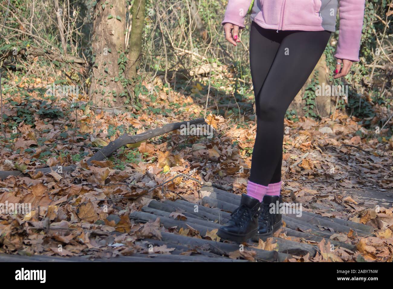Vita sana in natura, giovane donna vestita sportiva escursionismo, attraversando il piccolo ponte in legno Foto Stock