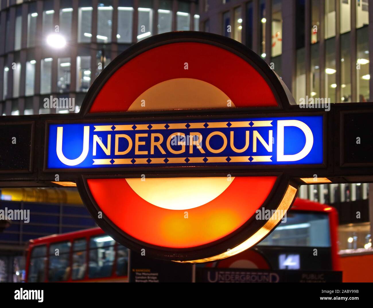 Segno della metropolitana di Londra di TfL di vecchio stile, al crepuscolo nella città di Londra, stazione della metropolitana della banca, distretto finanziario della città di Londra dietro, Inghilterra, Regno Unito Foto Stock