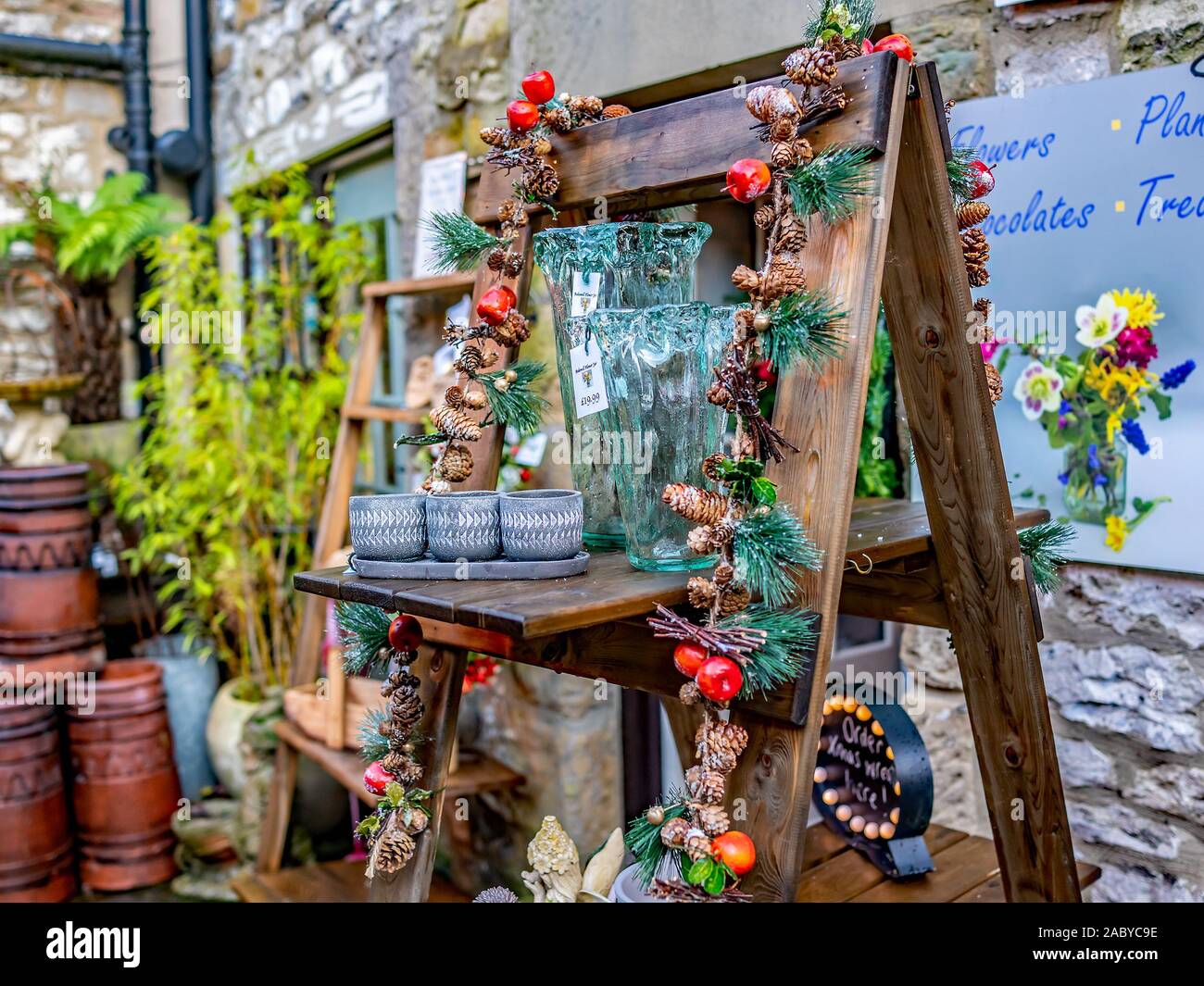 La selezione di una festosa stagionale e i regali di Natale sul display per la vendita in un piccolo cortile interno Foto Stock