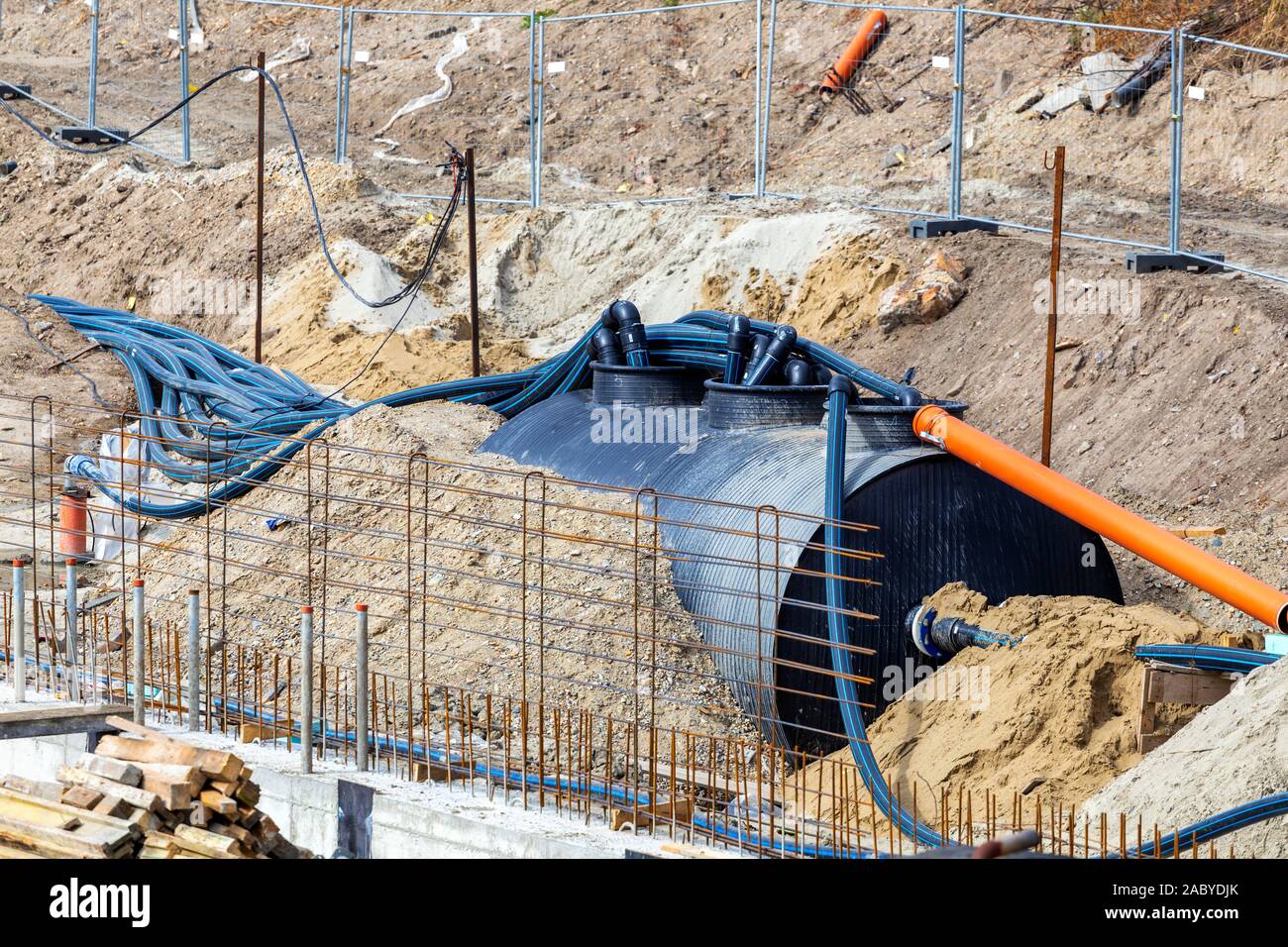 Il drenaggio del serbatoio di accumulo per l'acqua di allagamento con tubi sul sito in costruzione. Foto Stock