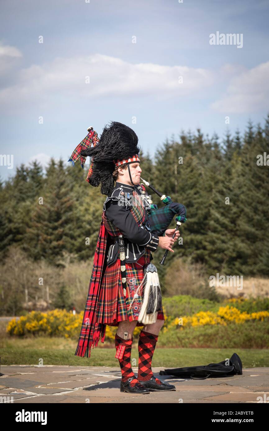 Un bagpiper svolge nella parte anteriore della seconda guerra mondiale Commando Memorial statua a Spean Bridge Foto Stock