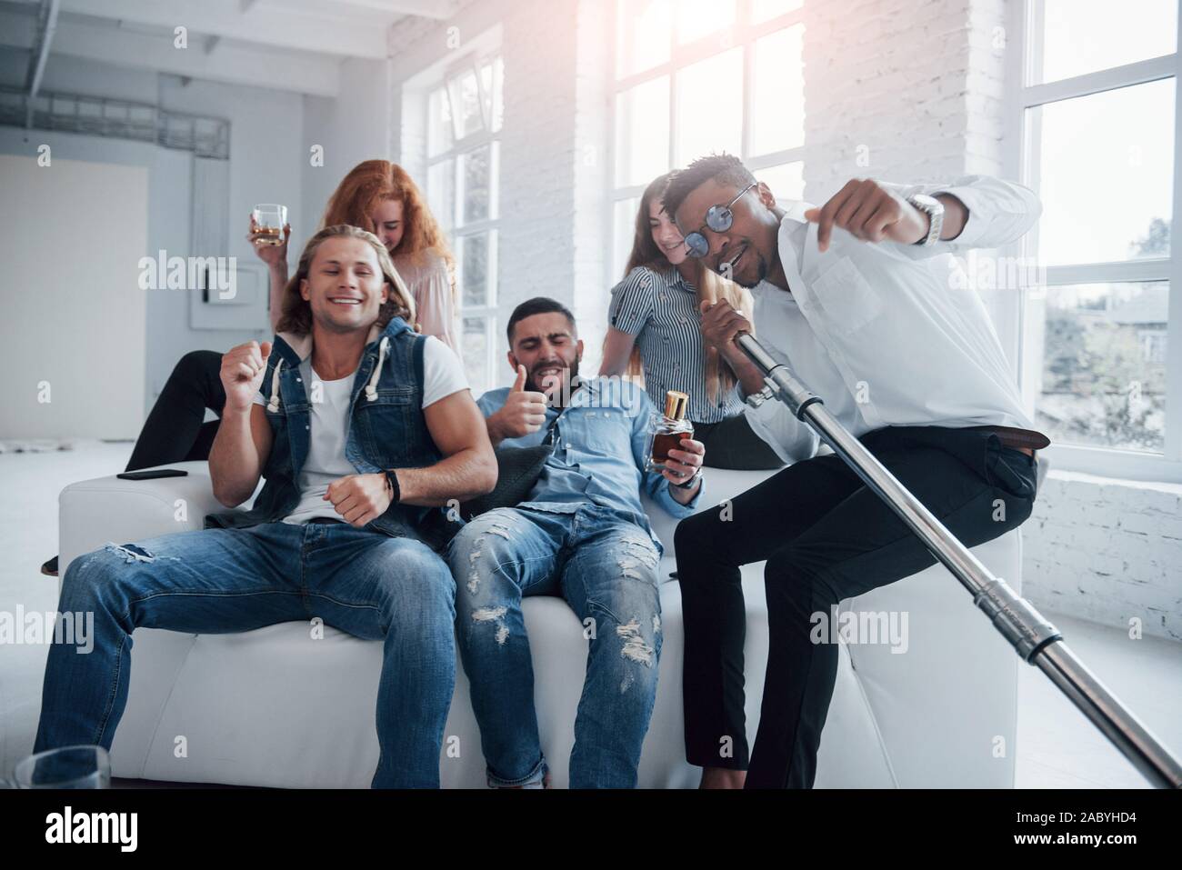 Atmosfera gioiosa. Gli amici decide di rilassarsi cantando i loro brani preferiti Foto Stock