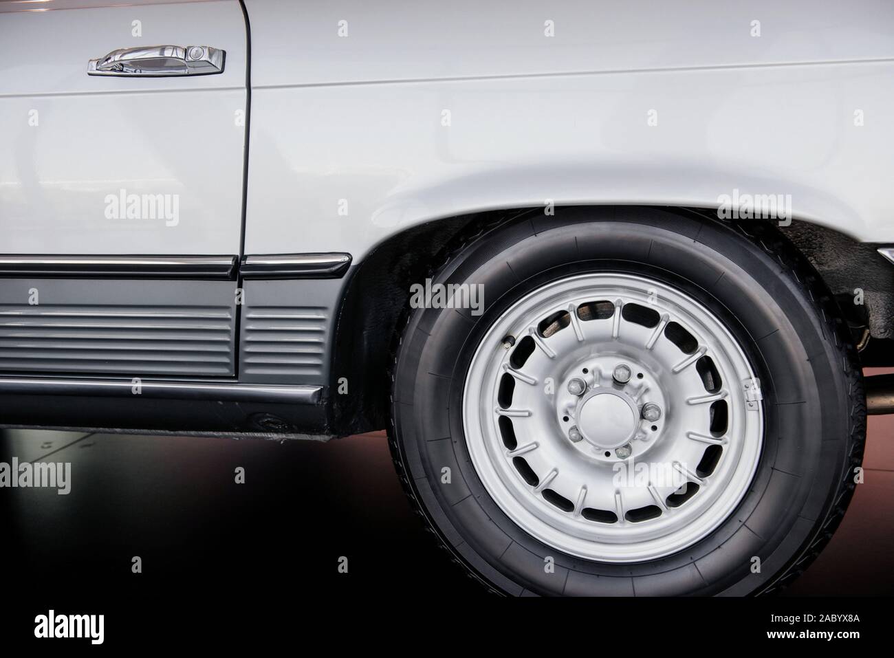 Lato Vista ravvicinata del bianco Auto retrò con il bianco ruota in lega leggera e a basso profilo pneumatico, disco cromato, arco sopra Foto Stock