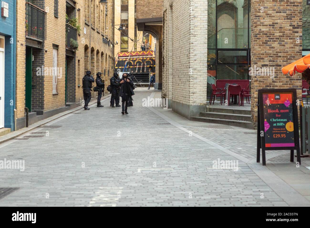 Borough Market, Londra, Regno Unito. 29 novembre 2019. Gli agenti armati della polizia metropolitana evacuano e bloccano Borough Market, Londra, a seguito di un attacco pugnalato al vicino London Bridge. Unità tattiche di arma da fuoco hanno assicurato l'area come parte di una risposta antiterrorismo. La scena mostra gli agenti con l'equipaggiamento protettivo posizionato lungo la strada acciottolata, con cartellonistica natalizia e offerte natalizie visibili sullo sfondo. L'incidente ha provocato un rapido blocco dell'area circostante durante le ore di punta del pomeriggio. Penelope Barritt/Alamy Live News Foto Stock