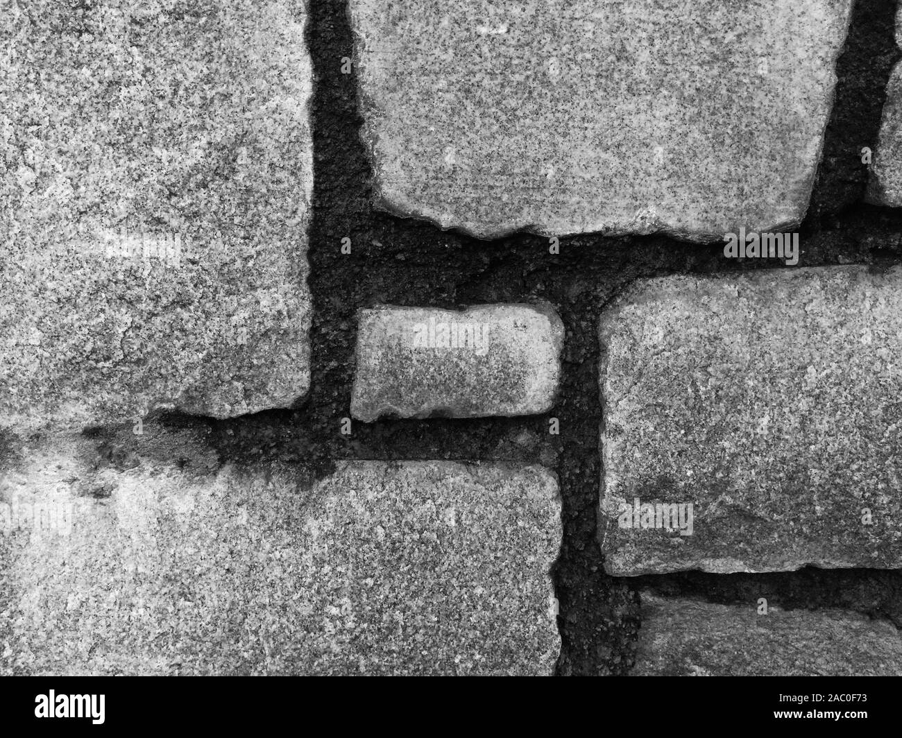 Le diverse texture in bianco e nero di un vecchio muro di pietra. Foto Stock