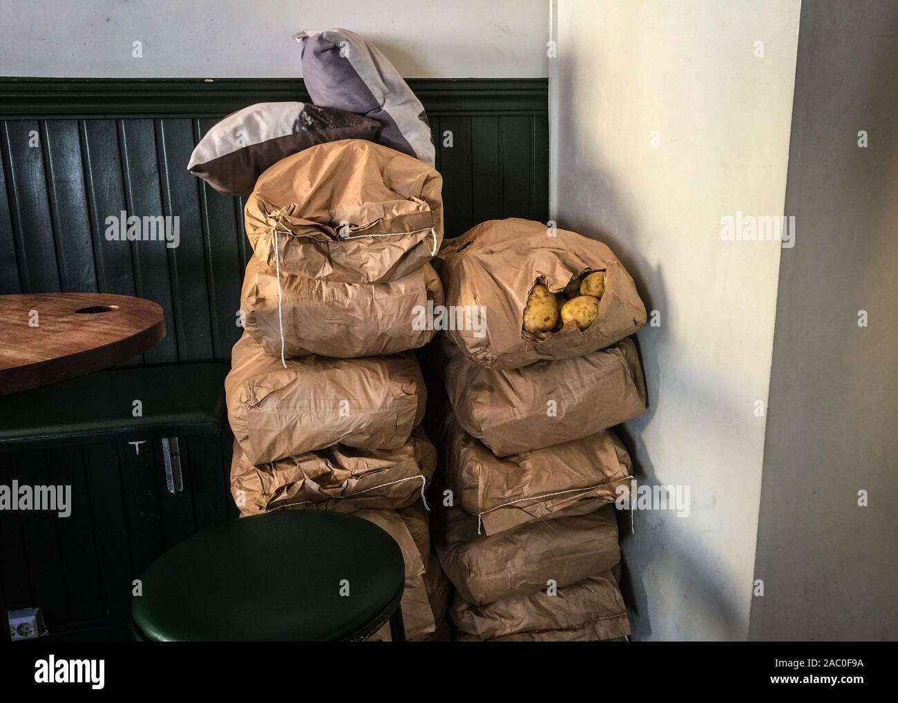 Due grandi pile di sacchi di patate sedersi in un angolo di un ristorante Foto Stock