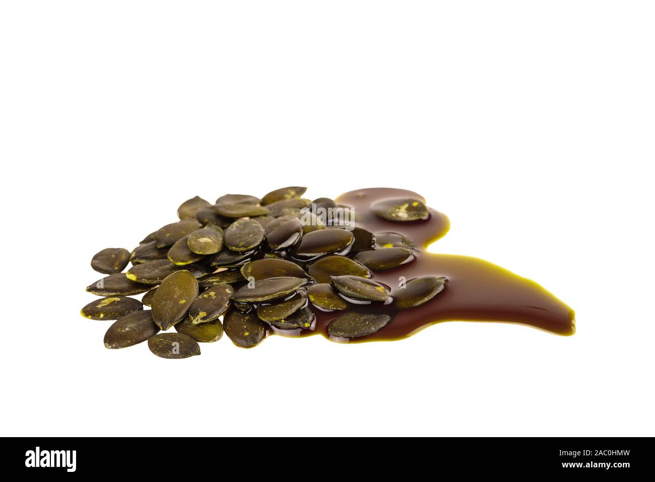 Semi di zucca con olio di semi di zucca isolato su bianco Foto Stock