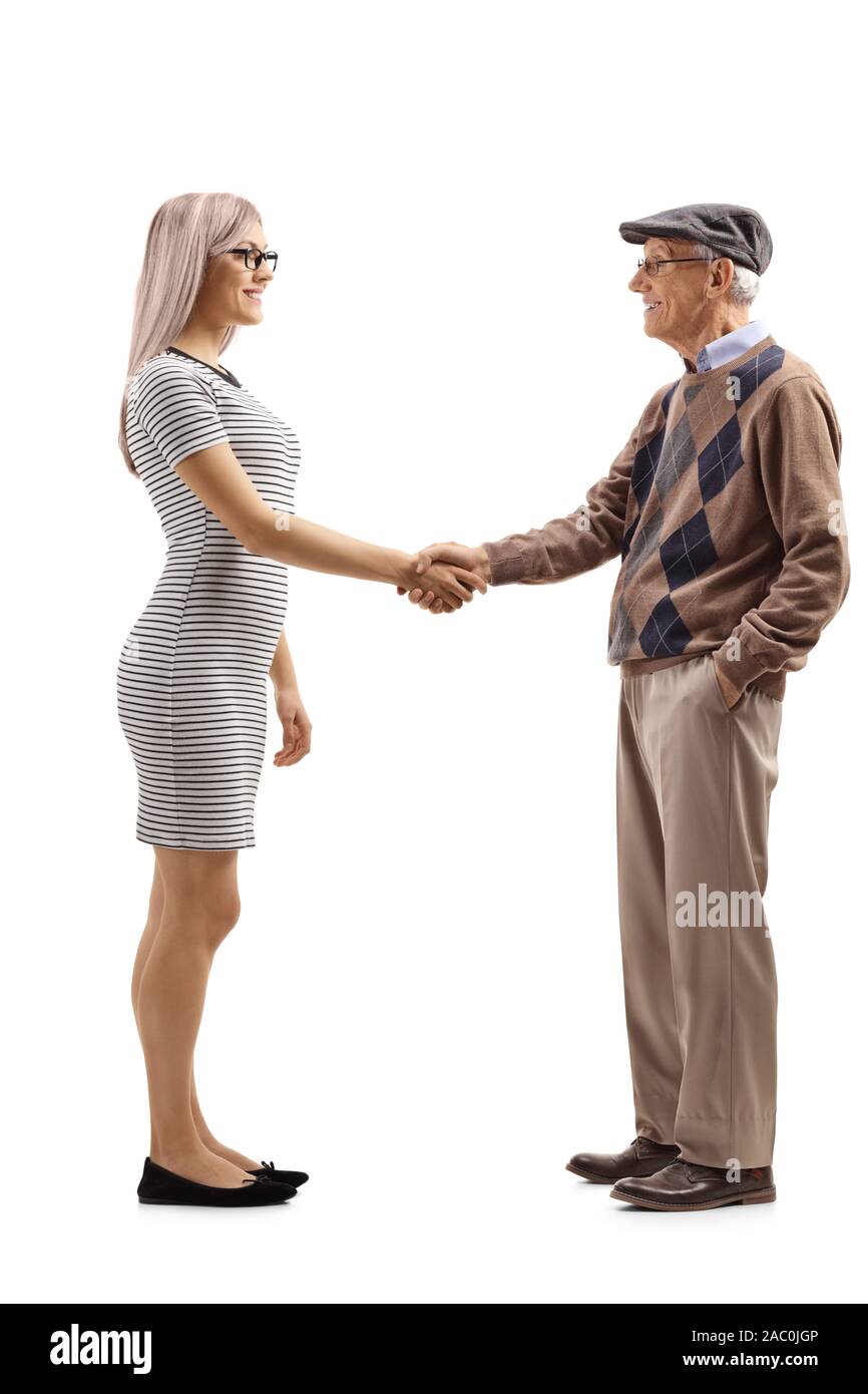 Lunghezza piena ripresa di profilo di una giovane donna si stringono la mano con un senior gentleman isolati su sfondo bianco Foto Stock