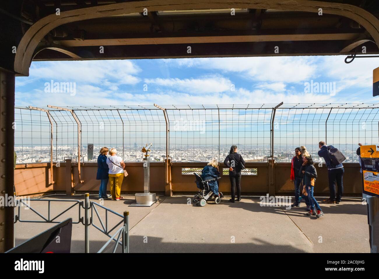 Turisti tra cui una donna su una sedia a rotelle godere la vista dalla prima piattaforma della torre Eiffel in una giornata di sole in Parigi Francia Foto Stock