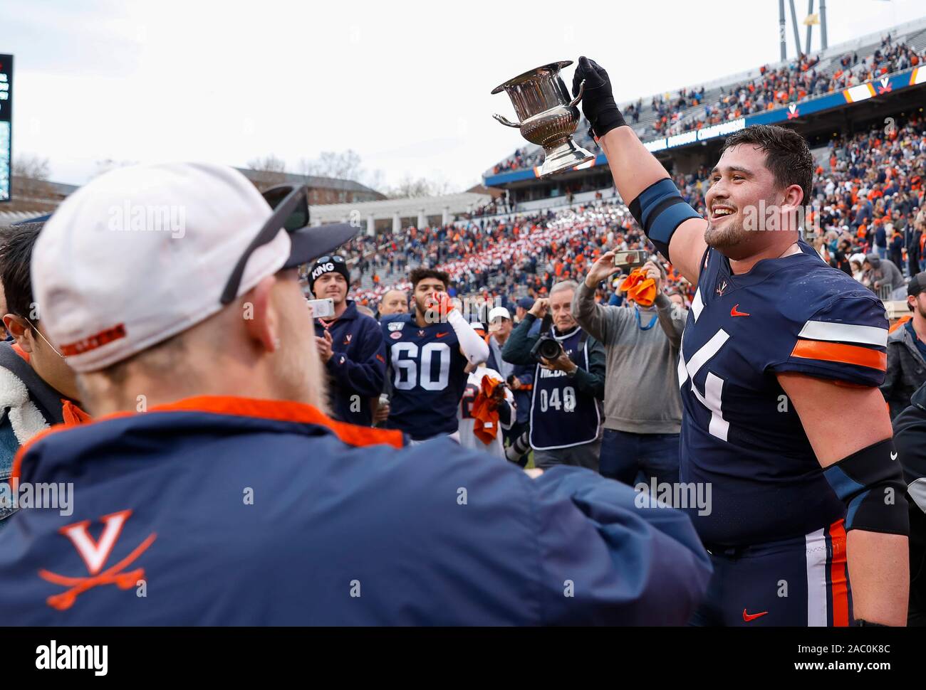 Charlottesville, Virginia, Stati Uniti d'America. 29 Nov, 2019. Virginia Cavaliers OT #54 Ryan Nelson montacarichi Commonwealth Cup dopo la NCAA Football gioco tra l'Università della Virginia Cavaliers e il Virginia Tech Hokies a Scott Stadium di Charlottesville, Virginia. Justin Cooper/CSM/Alamy Live News Foto Stock