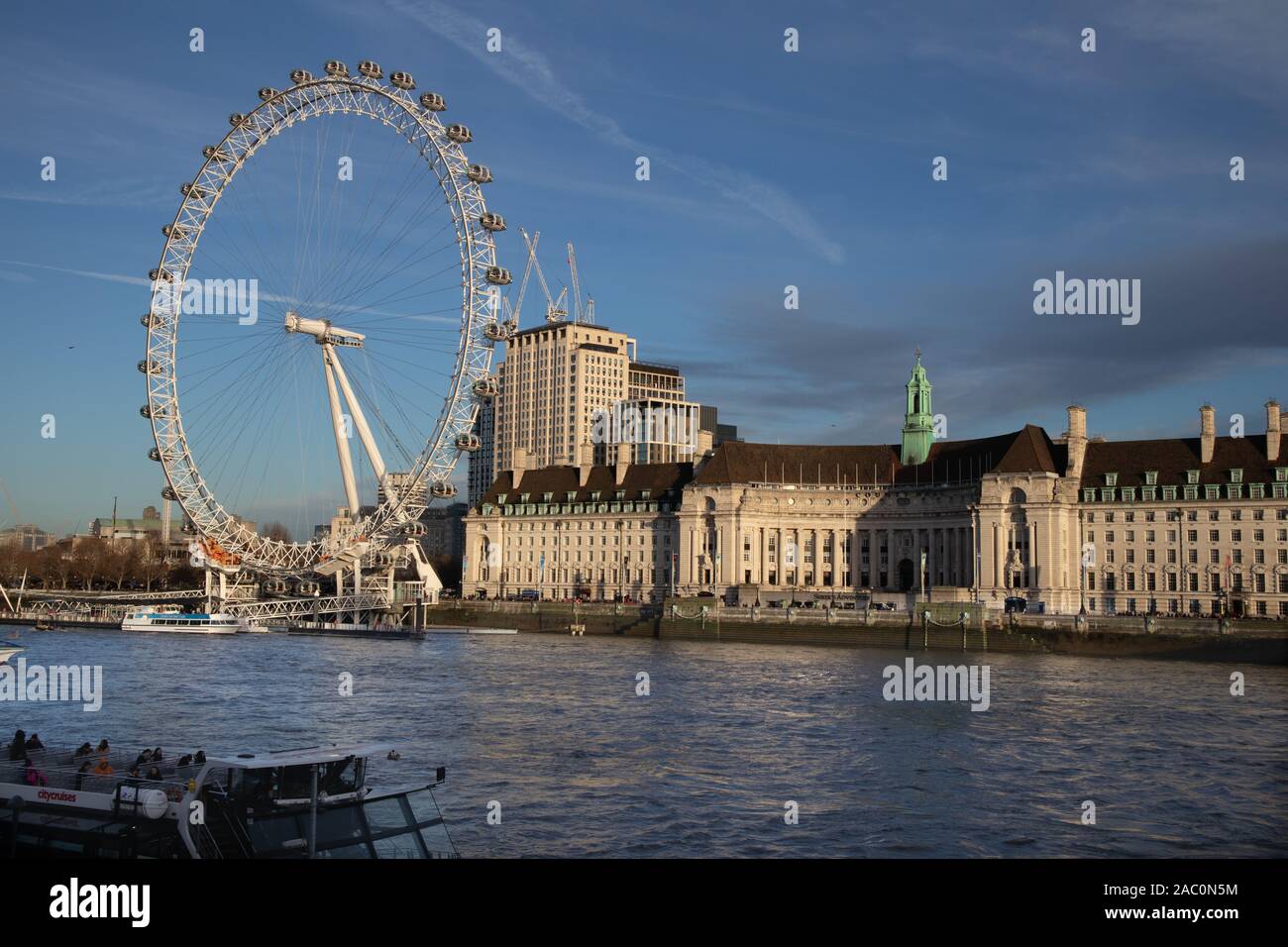 Vista del London Eye sulla riva sud del fiume Tamigi accanto a County Hall a Londra REGNO UNITO Foto Stock