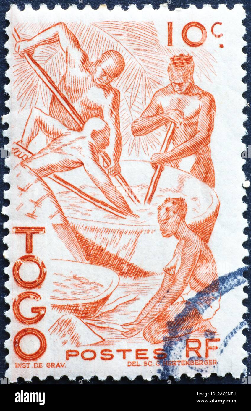 La gente di cottura degli alimenti sul vecchio francobollo del Togo Foto Stock