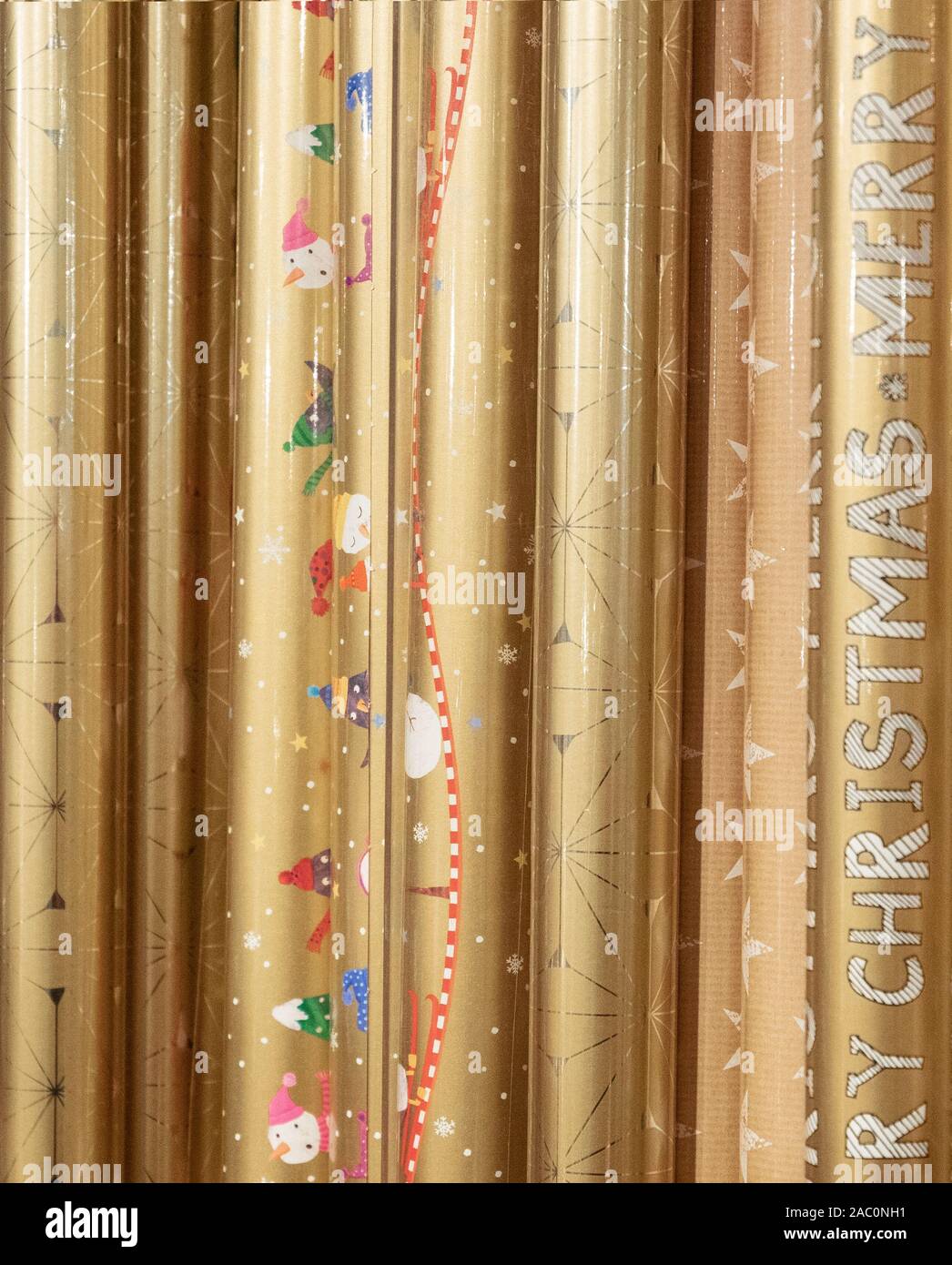 Rotoli di carta oro con decorazioni di Natale per avvolgere doni Foto Stock