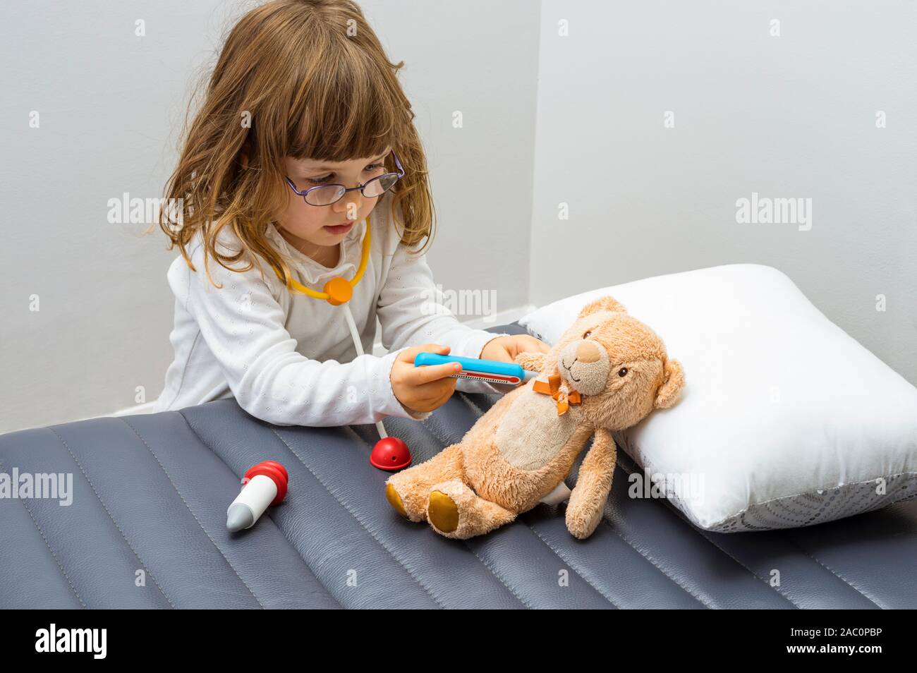 Bambino ragazza riproduzione medico con un giocattolo. Il salvataggio degli animali in pericolo di estinzione. Professione e il concetto di cura. Cancella sfondo neutro. Foto Stock