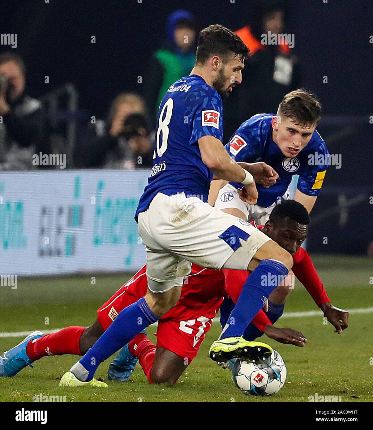 Gelsenkirchen (Germania). 29 Nov, 2019. Daniel Caligiuri (anteriore) e Jonjoe Kenny (retro) della Schalke 04 vie con Sheraldo Becker dell Unione Europea Berlino durante un match della Bundesliga a Gelsenkirchen, Germania, nov. 29, 2019. Credito: Joachim Bywaletz/Xinhua/Alamy Live News Foto Stock