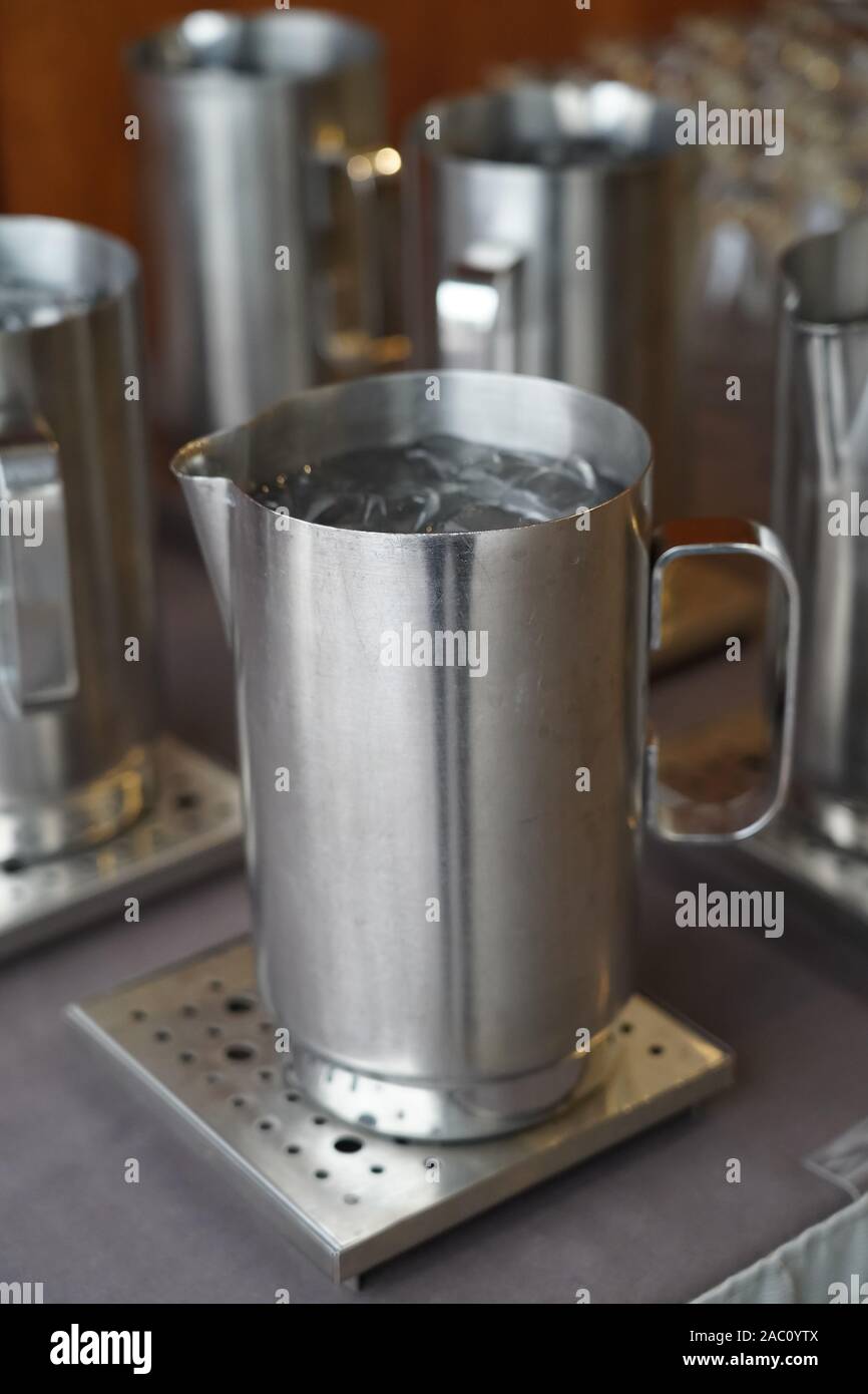 Un materiale metallico quale acciaio inossidabile brocca sul tavolo Foto Stock