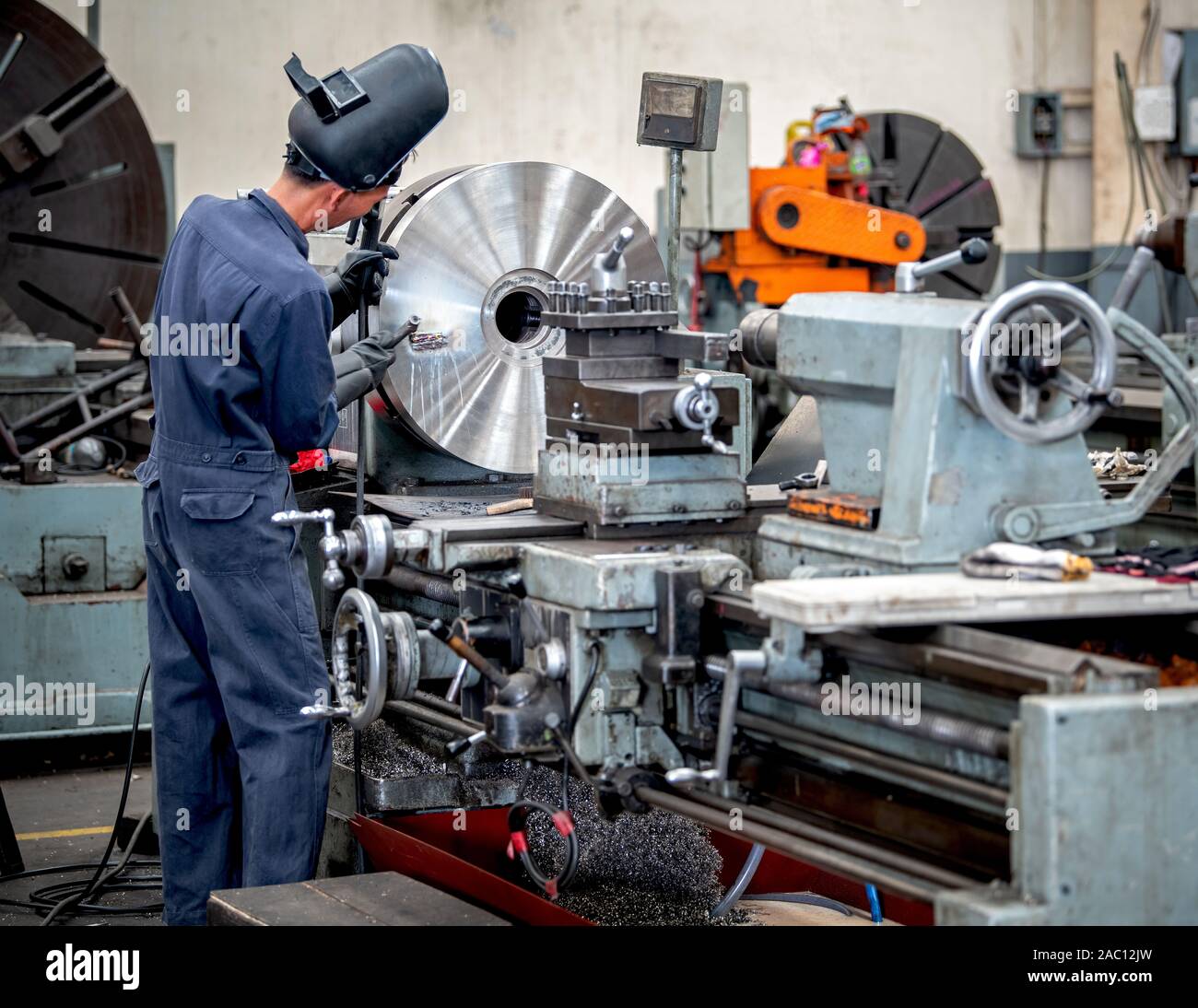 I lavoratori professionali stanno facendo il processo di fresatura per parti in metallo, metallo macchinari in grandi impianti industriali-image Foto Stock