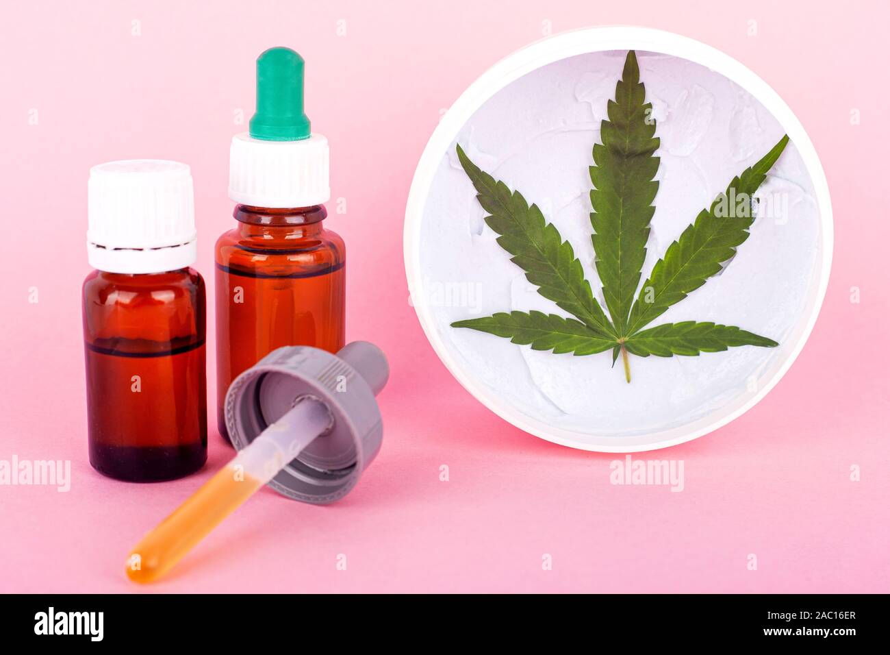 A base di cannabis oli cosmetici logo, bottiglie con estratto di marijuana e mano organico e crema per il viso per la pelle restauro . Foto Stock