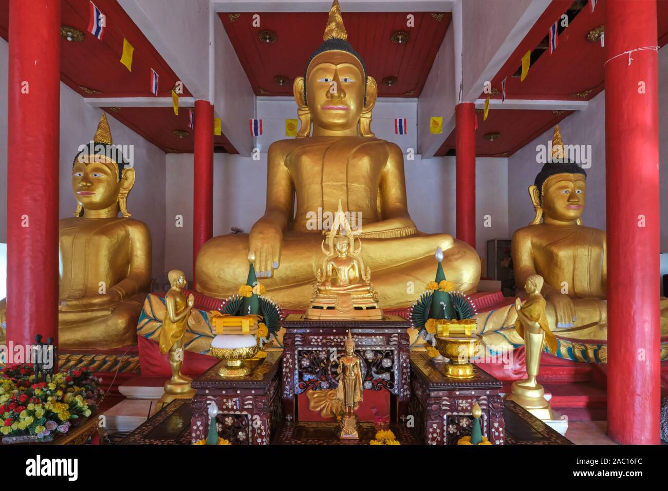 L antico stagno tre statue di Buddha nel vecchio bot o Ubosot (ordinazione hall) di Wat Phra Nang Sang, Thalang, Phuket, Tailandia Foto Stock