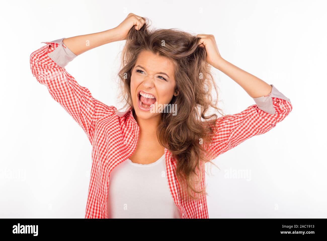 Ritratto di bimba pazza gridando e tenere i capelli Foto stock - Alamy