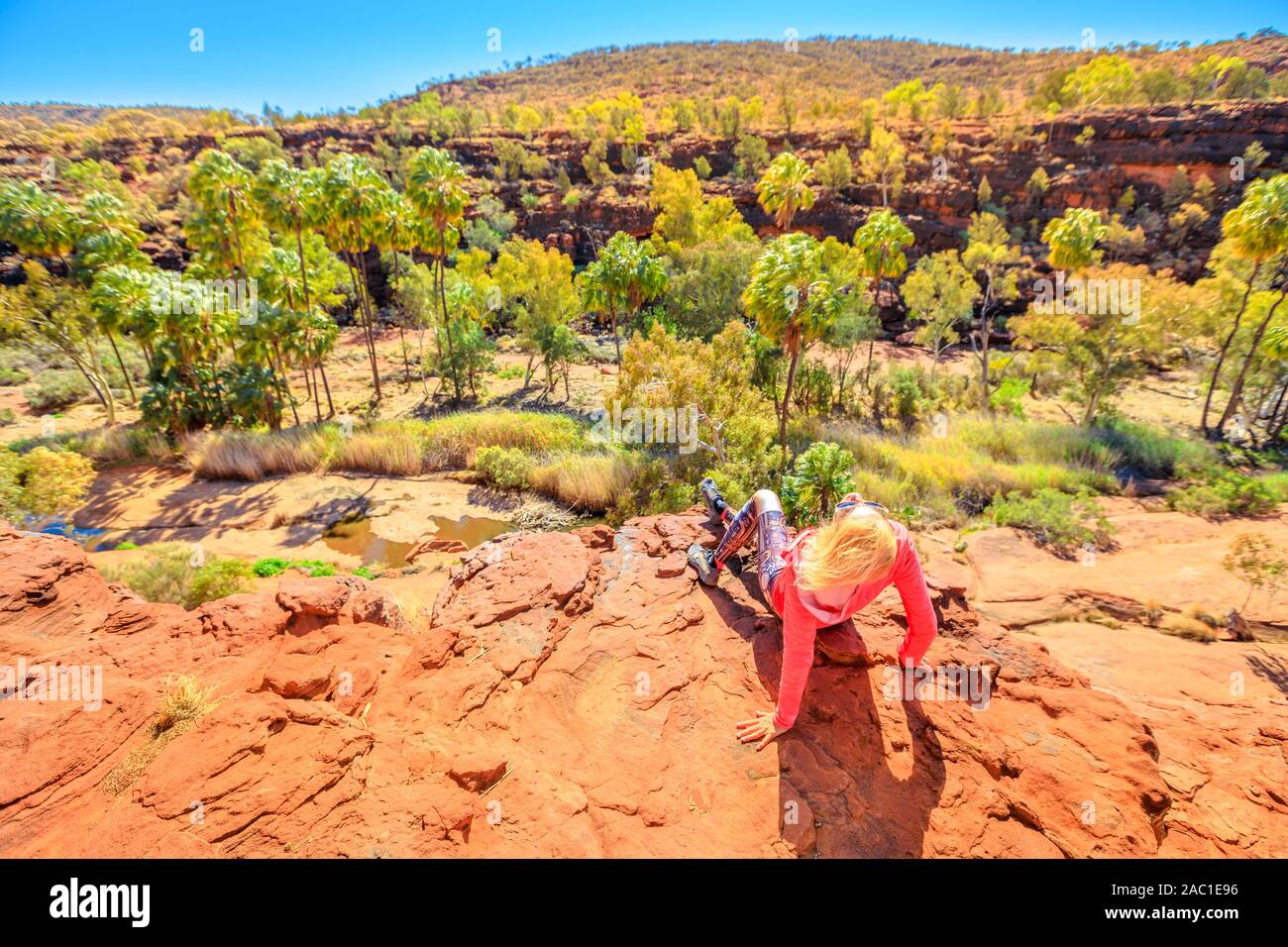 Donna riposo dopo Arankaia trekking a piedi. Panoramica del cavolo rosso Palm in Palm Valley. Finke Gorge National Park nel Territorio del Nord, Centrale Foto Stock