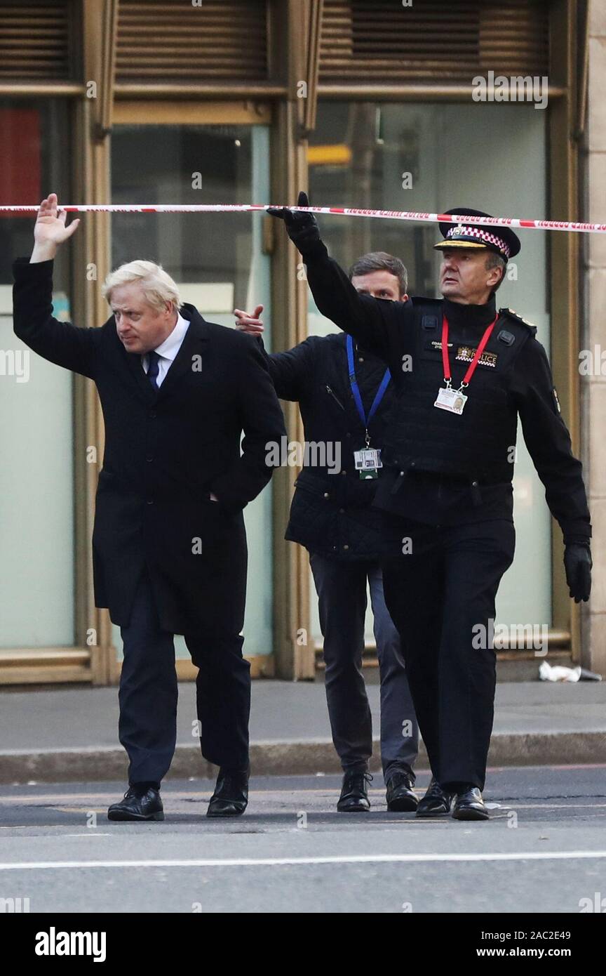 Il primo ministro Boris Johnson e il Commissario della City of London Police Ian Dyson frequentare il Ponte di Londra della scena del crimine in centro a Londra dopo un terrorista che indossa un finto giubbotto di suicidio che è andato su un coltello rampage uccidendo due persone, è stato ucciso dalla polizia. Foto Stock