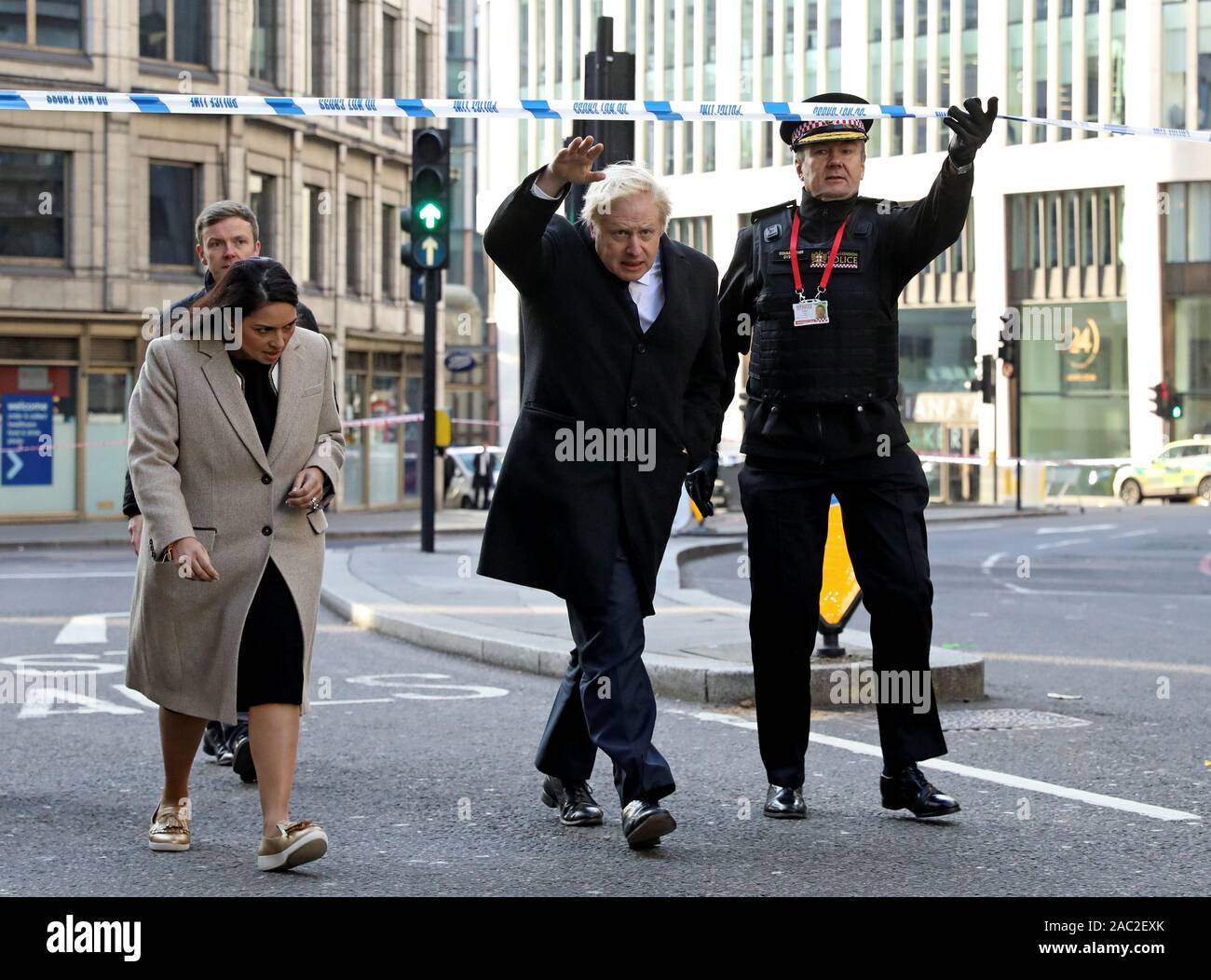 (Da sinistra a destra) Home Secretary Priti Patel, Primo Ministro Boris Johnson e il Commissario della City of London Police Ian Dyson frequentare il Ponte di Londra della scena del crimine in centro a Londra dopo un terrorista che indossa un finto giubbotto di suicidio che è andato su un coltello rampage uccidendo due persone, è stato ucciso dalla polizia. Foto Stock