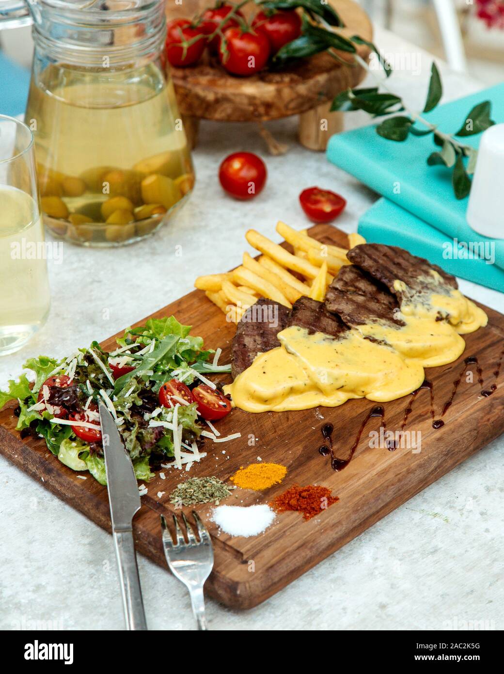 Carne arrosto di formaggio fuso e le patatine fritte con insalata Foto Stock